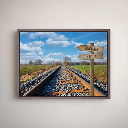 Personalisierbares Leinwandbild mit Eisenbahnschienen, Wegweiser mit Namen, Landschaft und Himmel